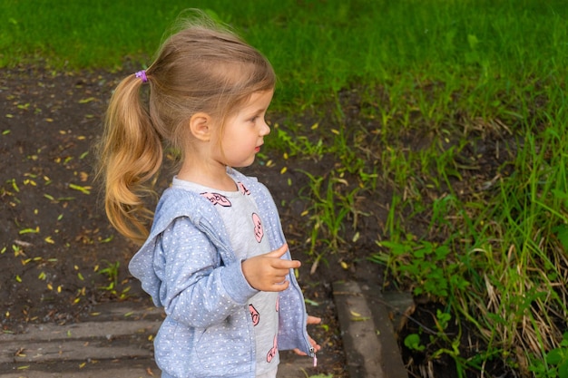Bambina in piedi all'aperto nel parco nel giorno d'estate