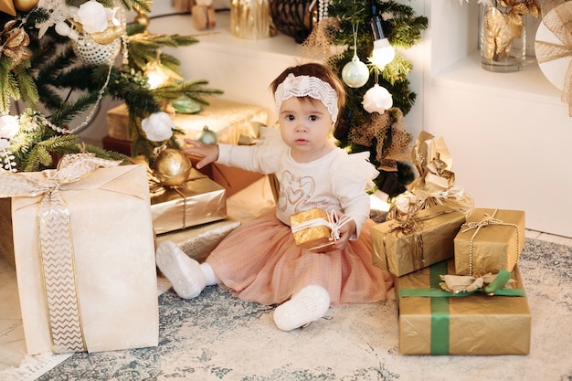 Bambina in piedi vicino all'albero di Natale decorato