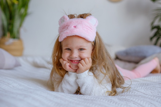 Bambina in pigiama sdraiato sul letto