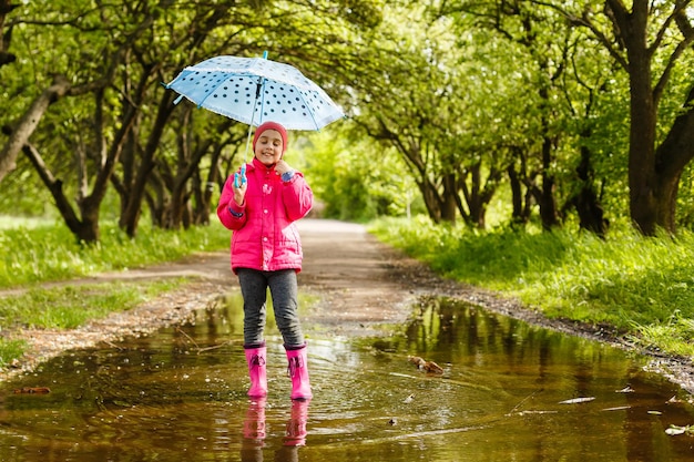 bambina in sella alla bici nella pozza d'acqua