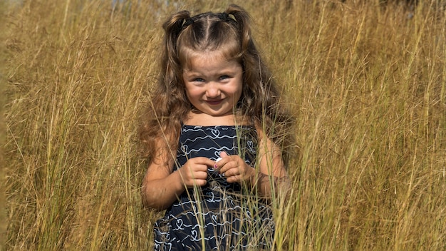 bambina in un campo con erba. bambino in natura. striscione