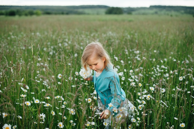 Bambina in un campo di camomilla