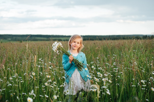 Bambina in un campo di camomilla