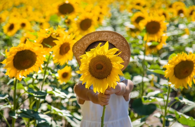 Bambina in un campo di girasoli. Messa a fuoco selettiva.