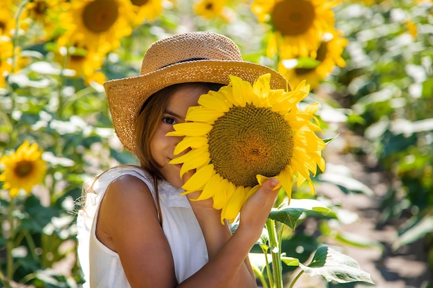 Bambina in un campo di girasoli. Messa a fuoco selettiva.