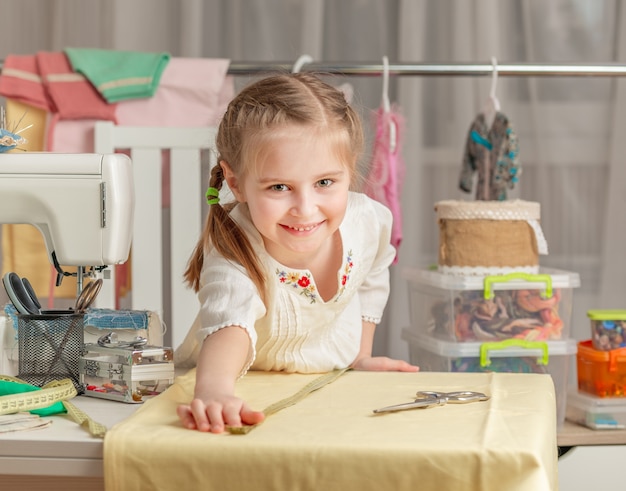 Bambina in un laboratorio di cucito