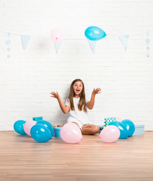 Bambina in una festa di compleanno giocando con palloncini