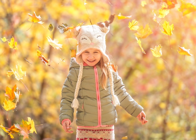 Bambina in una foresta d'autunno