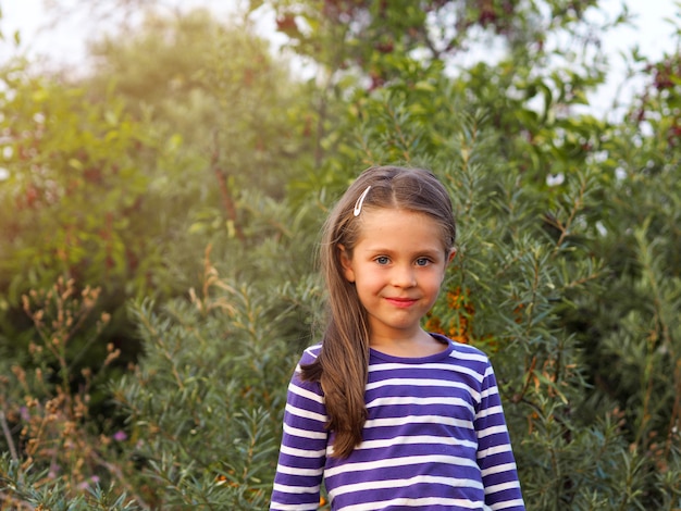 Bambina in una giacca a righe in natura