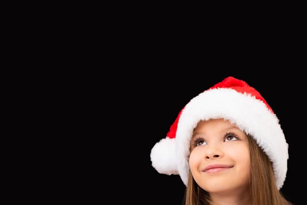 Bambina in una posa del cappello di Natale.