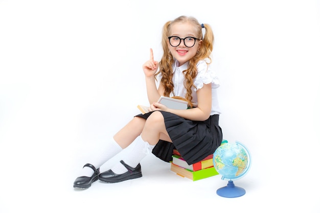 bambina in uniforme scolastica con gli occhiali isolati su sfondo bianco