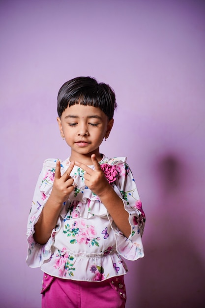 Bambina indiana che fa matematica contando le dita a casa