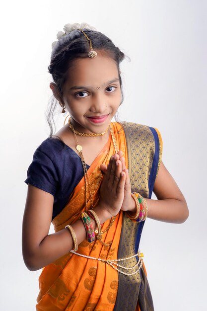 Bambina indiana marathi nel tradizionale saree blu navwari su sfondo bianco