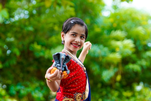 Bambina indiana sveglia che celebra il festival di Lord Ganesha