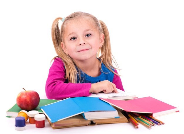 Bambina intelligente che tiene un libro e lo legge su uno sfondo bianco