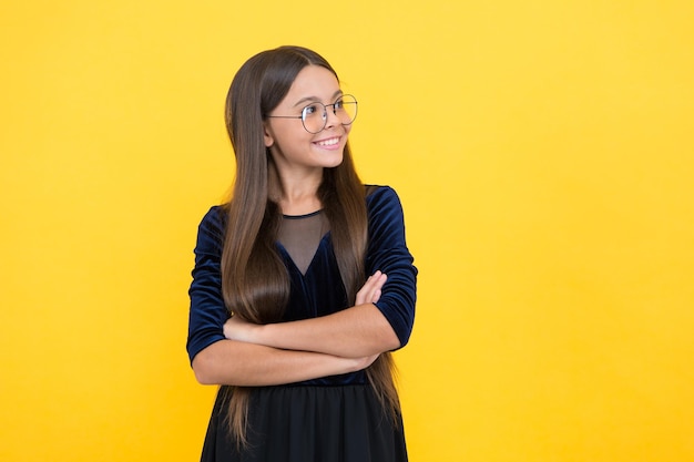 Bambina intelligente con capelli lunghi e occhiali su sfondo giallo, stile.