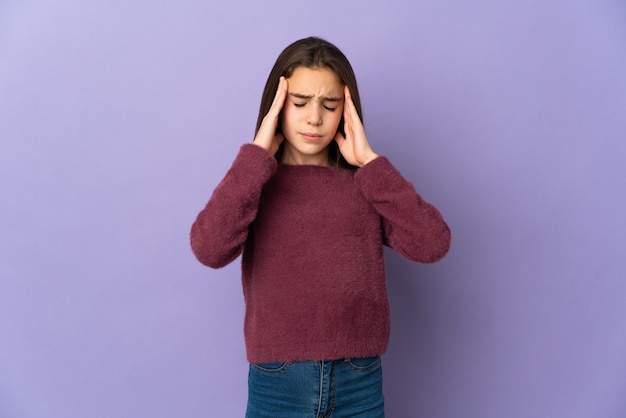 Bambina isolata su sfondo viola con mal di testa