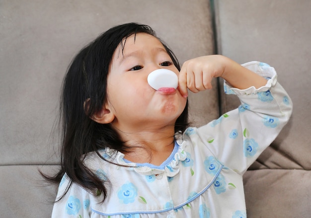 Bambina malata che dà la medicina da sola