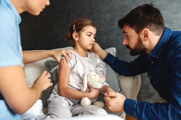 Bambina malata che ottiene un colpo con la cura