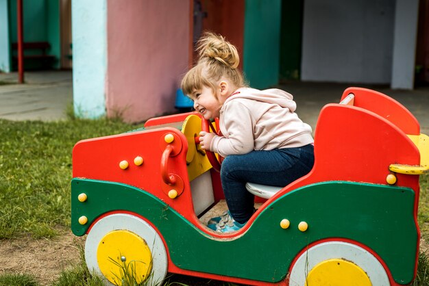 Bambina nel parco giochi. Bambino sorridente felice che gioca all'aperto. Il bambino ride, grida emotivamente, gioia e un'infanzia felice.