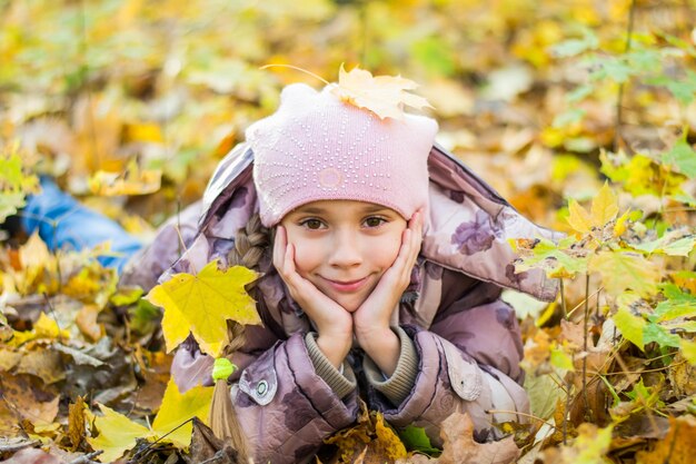 Bambina nel parco sullo sfondo di fogliame e alberi