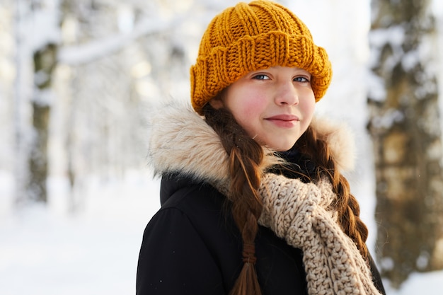 Bambina nella foresta invernale