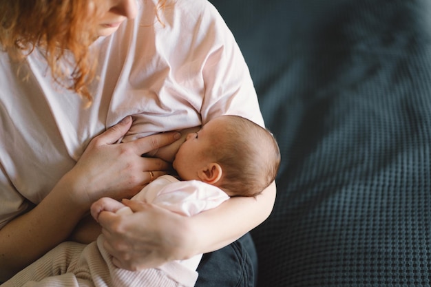 Bambina neonata che succhia il latte dal petto della madre
