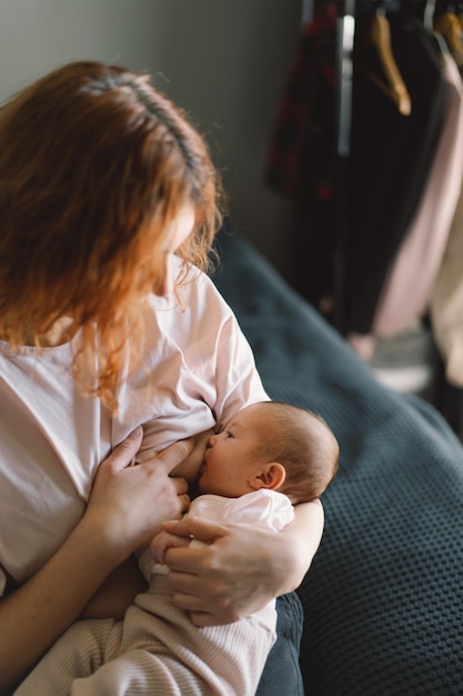 Bambina neonata che succhia il latte dal petto della madre