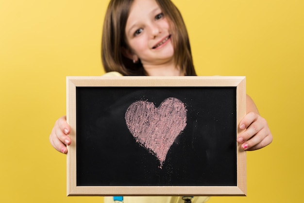 Bambina orgogliosa che mostra il disegno del cuore