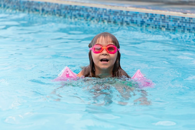 Bambina piccola che nuota da sola nelle piscine