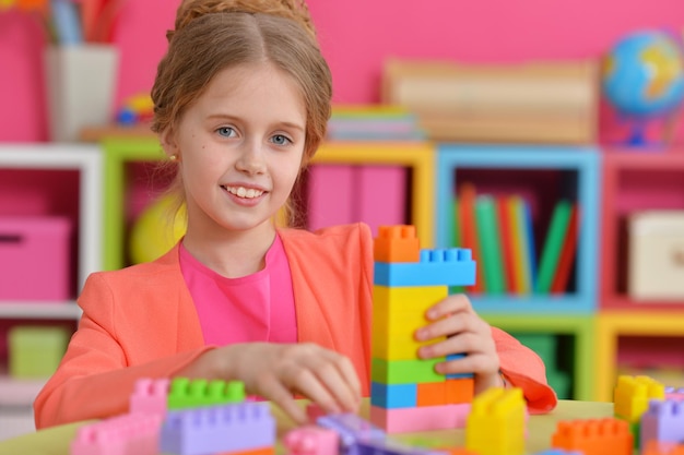 Bambina riccia che gioca con blocchi di plastica colorati