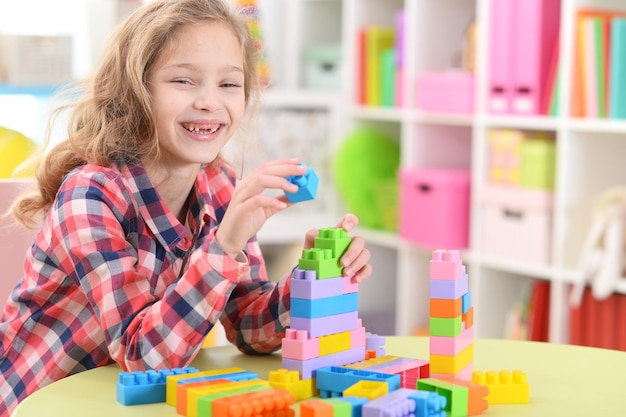 Bambina riccia che gioca con blocchi di plastica colorati