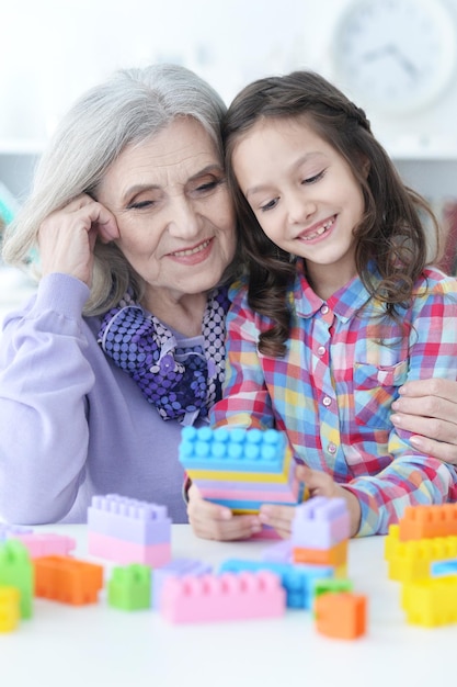 Bambina riccia e sua nonna che giocano con blocchi di plastica colorati