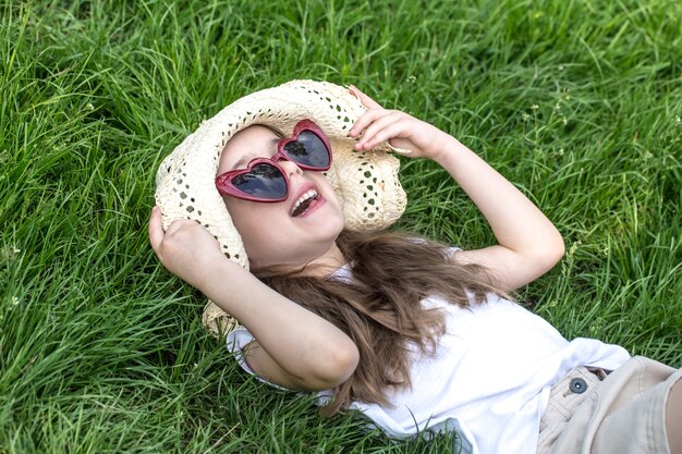 bambina sdraiata sull'erba. ora legale e giornata di sole