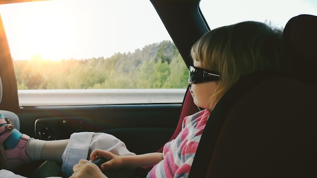 Bambina seduta in un seggiolino auto sul retro dell'auto