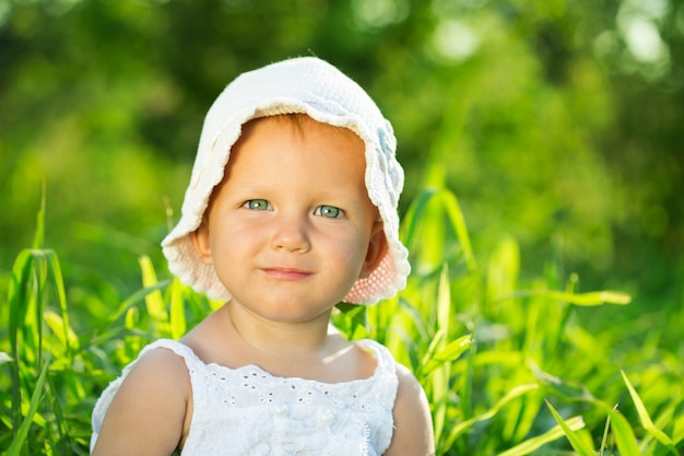 Bambina seduta nell'erba verde