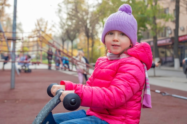 Bambina seduta su un'altalena in legno