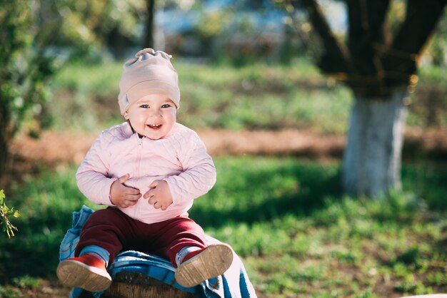 Bambina seduta su una botte di legno nel giardino del villaggio con la nonna