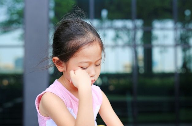 Bambina seria con postura la mano sulla guancia