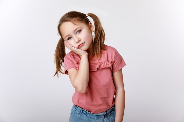 Bambina soffre di mal di denti tenendo la sua guancia