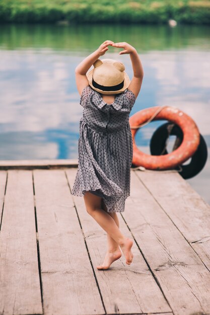 Bambina solitaria seduta sul molo