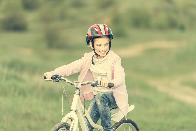 Bambina sorridente che guida una bici