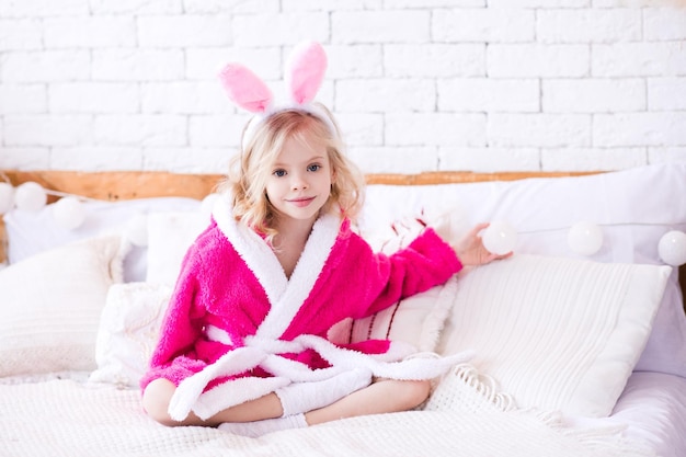 Bambina sorridente che indossa una fascia da coniglio in camera