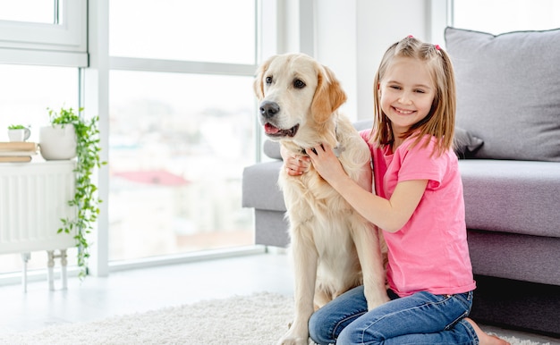 Bambina sorridente che stringe a sé cane sveglio