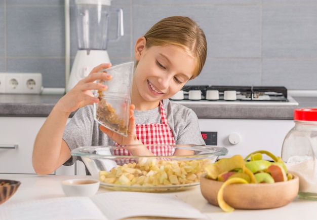 Bambina sorridente con le mele tagliate in ciotola