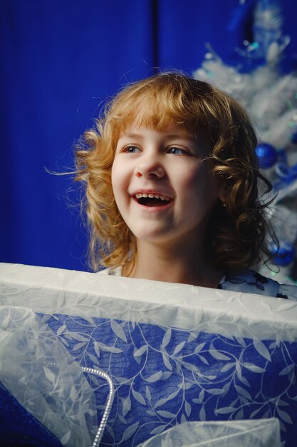 Bambina sorridente con una grande confezione regalo.