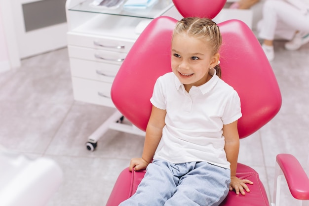 Bambina sorridente durante una visita dal dentista presso la clinica dentale