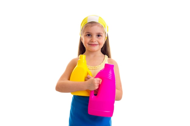 Bambina sorridente in camicia gialla e grembiule blu con fazzoletto giallo che tiene giallo