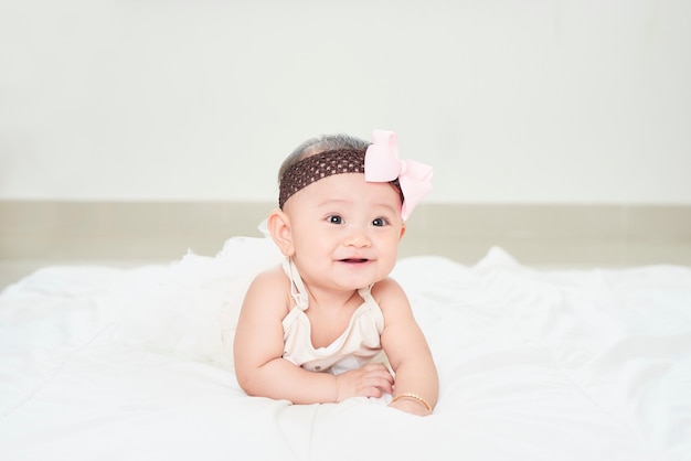 Bambina sorridente sul pavimento isolato su bianco