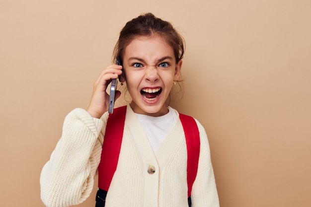 Bambina studentessa zaino telefono in mano sfondo isolato